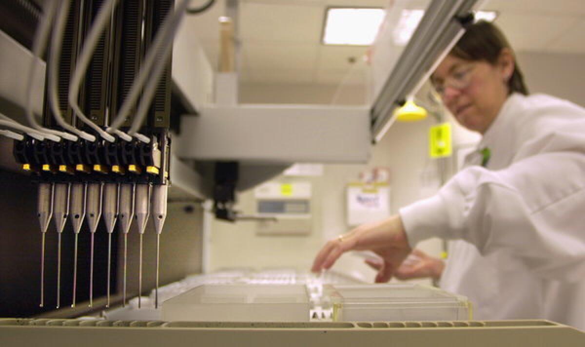 A technician loads patient samples into a machine for testing at Myriad Genetics Friday, May 31, 2002, in Salt Lake City. DNA samples are moved from one tray to another by the eight-needle apparatus at left. The Supreme Court ruled Thursday that Myriad Genetics Inc. cannot patent the BRCA genes, which are tested to check a woman's risk for breast and ovarian cancer.