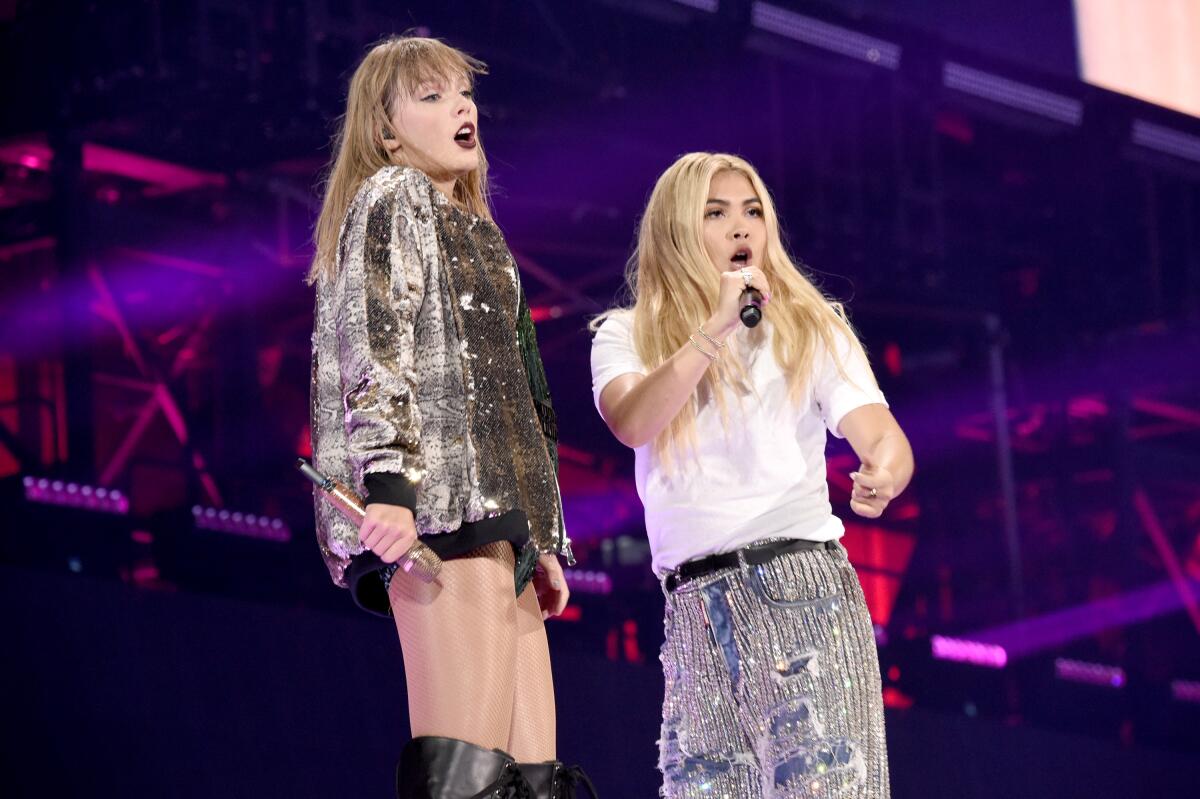 Taylor Swift, left, and Hayley Kiyoko onstage.
