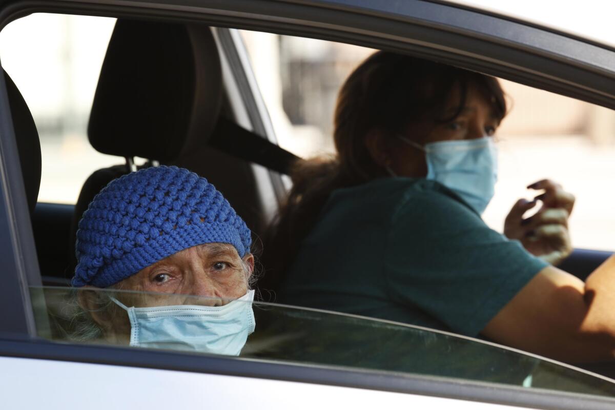 Antonia Jandres, 87, and her daughter Marta Jandres, wait in a line of cars to receive a test for COVID-19 at the Crenshaw Christian Center in South Los Angeles.