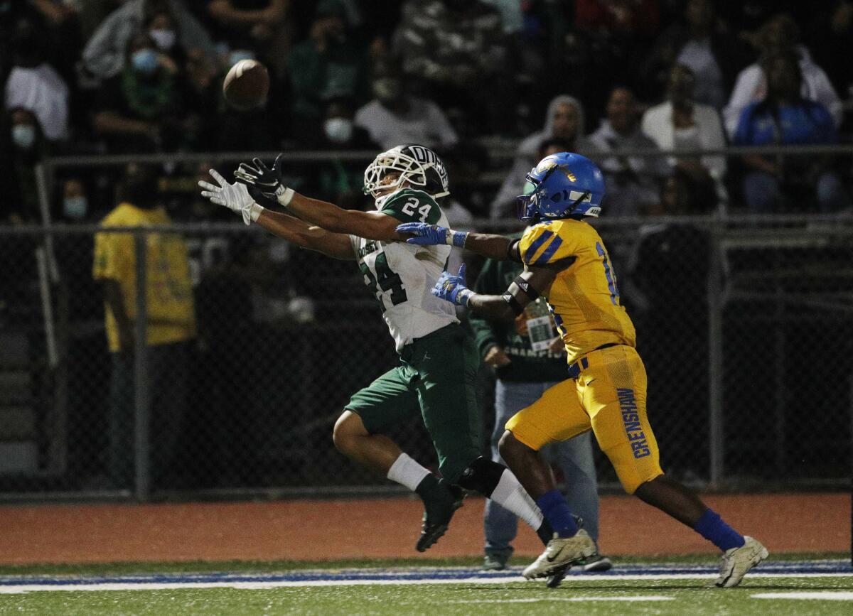 Dorsey running back Harrison Allen reaches out but can't make a catch as Crenshaw's Andrew Wynn tries to cover him.