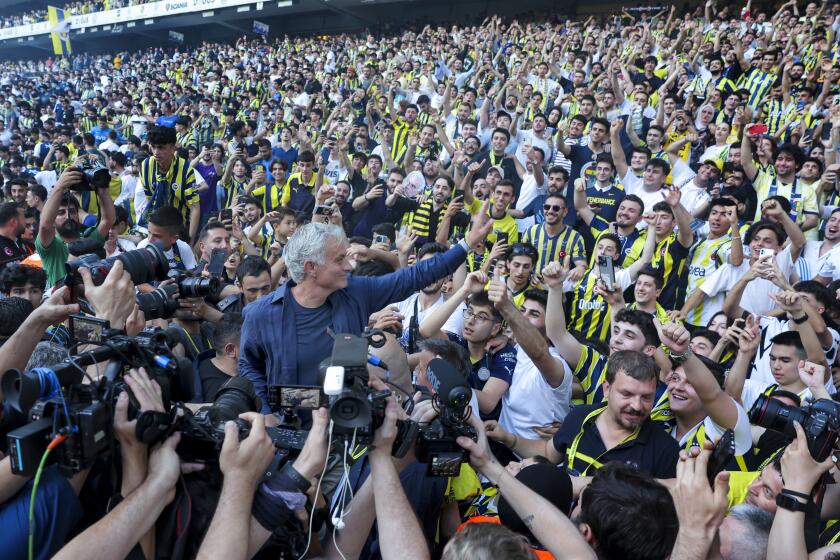 El técnico José Mourinho (centro) saluda a la afición durante su presentación como técnico de Fenerbahce en el estadio Sukru Saracoglu, el domingo 2 de junio de 2024, en Estambul. (AP Foto)