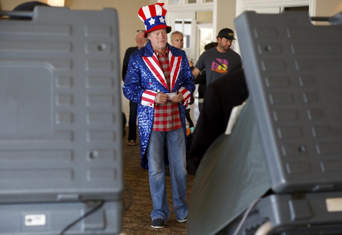 Kent Barkouras, 55, of Newport Beach, wears a patriotic costume as he waits in line to vote at the Lido Isle Clubhouse on Tuesday.