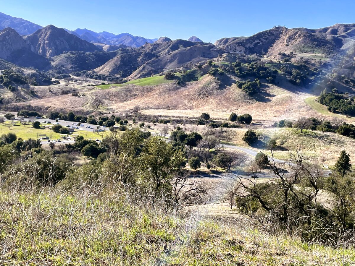 The hills of Calabasas with some greenery in the front but mostly dry, beige-colored grass.