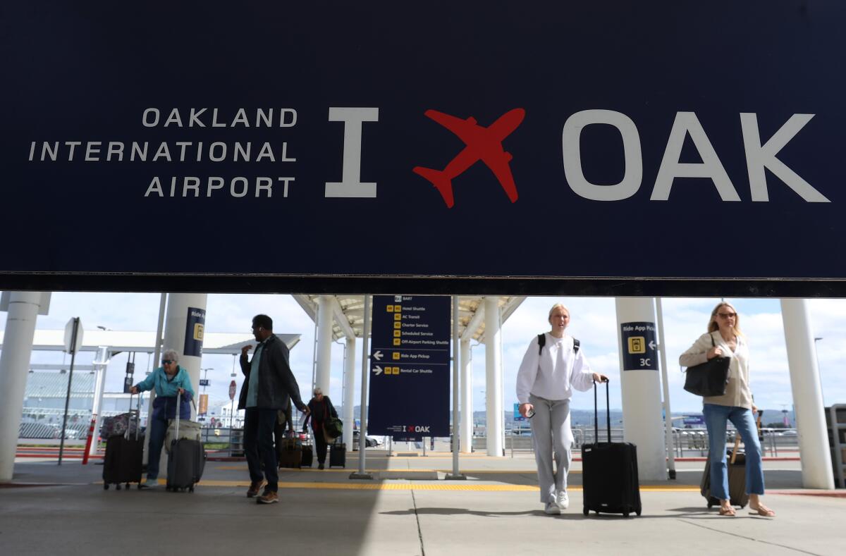 Travelers walk toward Terminal 2 at San Francisco Bay Oakland International Airport.