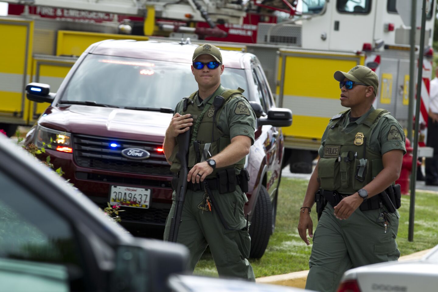 Maryland state police officers patrol the area near the scene of a shooting at the Capital newspaper.