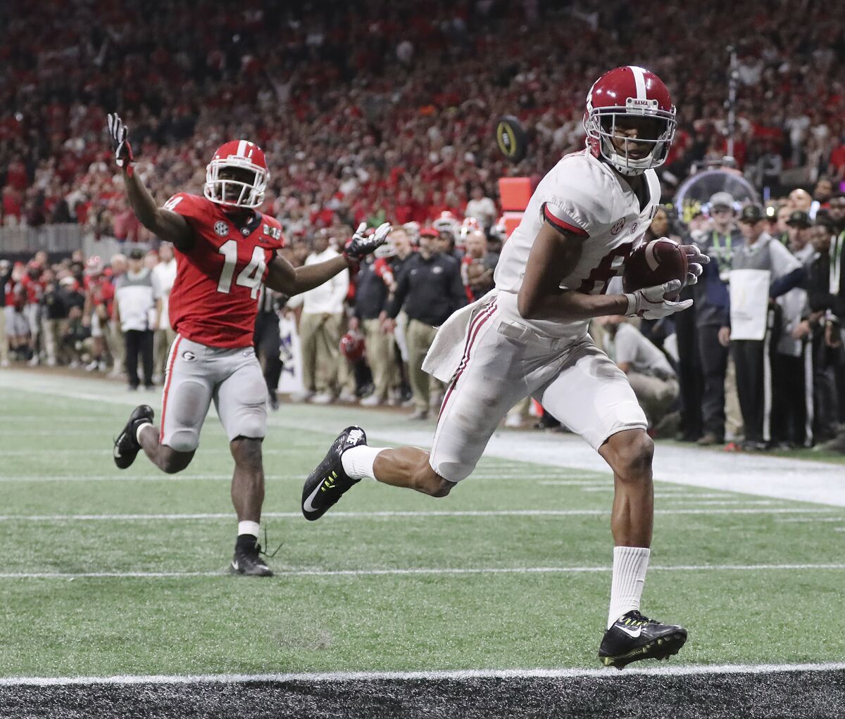 FILE - Alabama wide receiver Devonta Smith runs into the end zone for a touchdown after catching a pass past Georgia defensive back Malkom Parrish during overtime of the NCAA college football playoff championship game in Atlanta on Monday, Jan. 8, 2018. Alabama won 26-23. (Curtis Compton/Atlanta Journal-Constitution via AP, File)