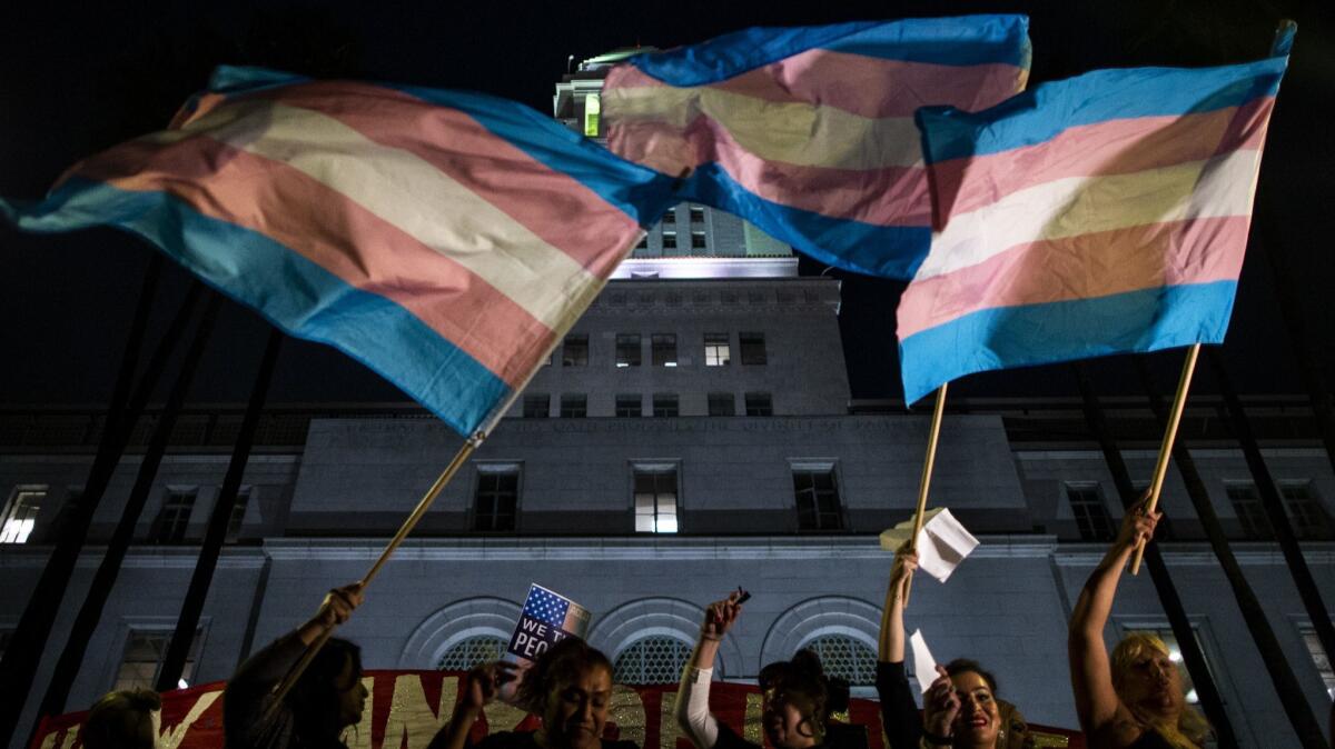 Flags are waved as people gather on the steps of Los Angeles City Hall for a rally in support of transgender rights on Oct. 22.