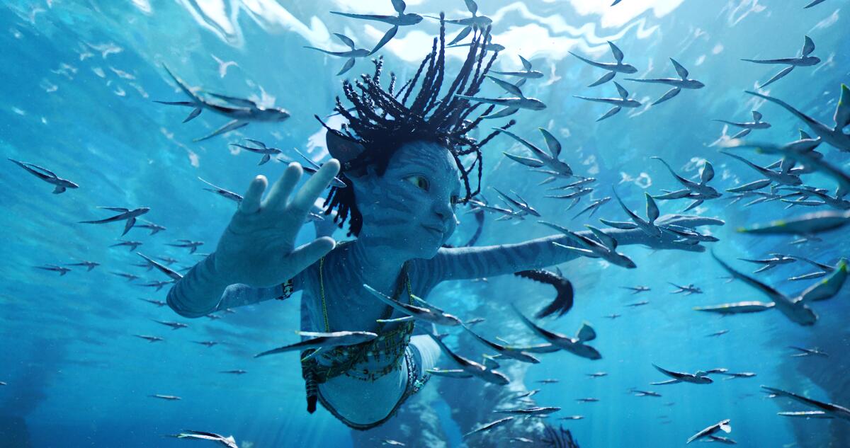 A blue alien child swimming underwater among sea creatures.