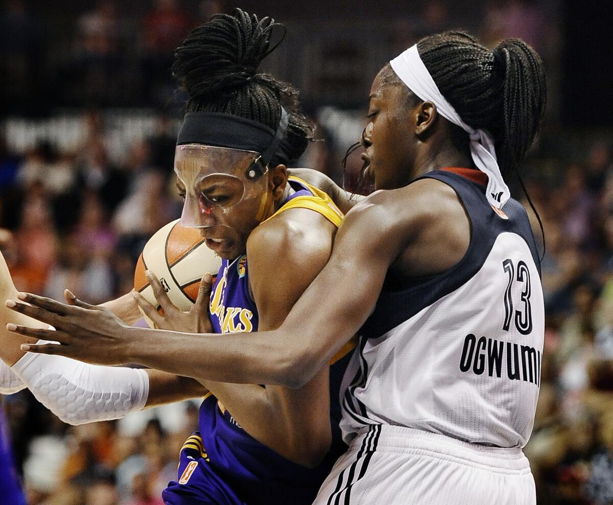 Sparks' Nneka Ogwumike, left, is guarded by sister Chiney Ogwimike of the Connecticut Sun nduring a WNBA game on July 13.