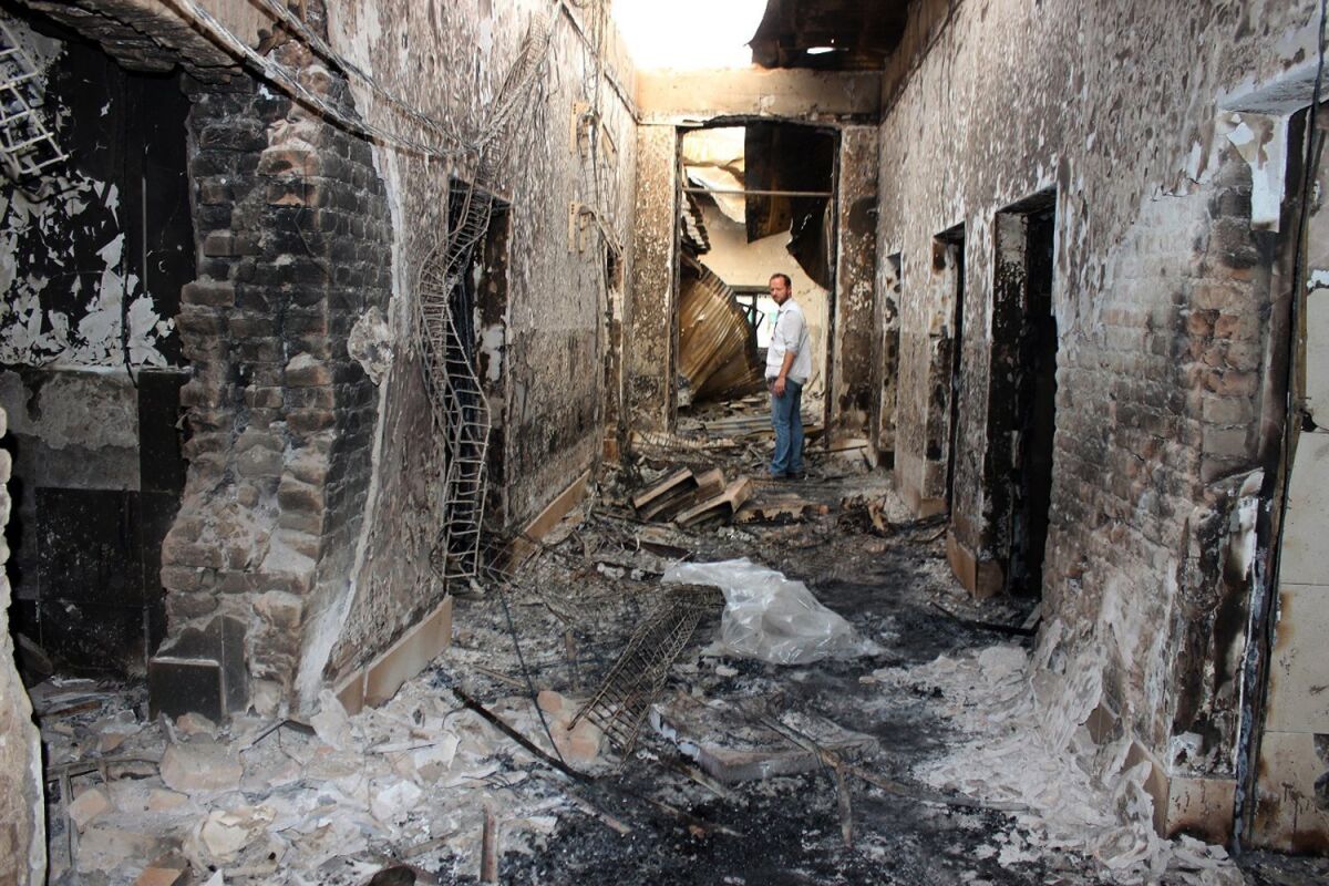 In this Oct. 16, 2015, file photo, an employee of Doctors Without Borders stands amid the charred remains of the medical charity's hospital after it was hit by a U.S. airstrike in Kunduz, Afghanistan.