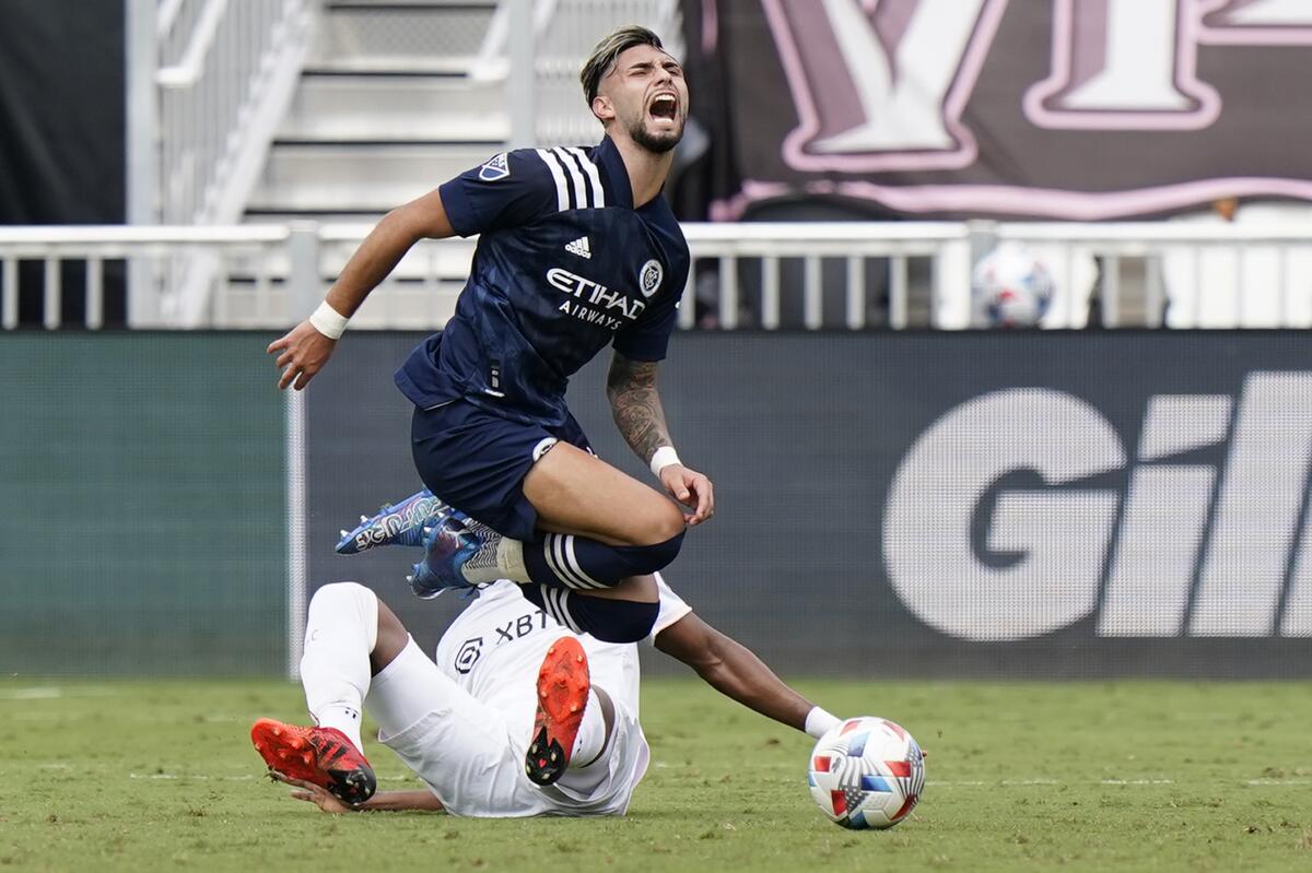New York City FC midfielder Valentin Castellanos trips over Inter Miami defender Christian Makoun, Saturday, Oct. 30, 2021, during the first half of an MLS soccer match in Fort Lauderdale, Fla. (AP Photo/Wilfredo Lee)