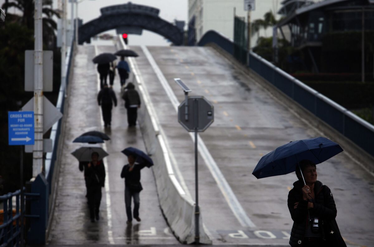 Pedestrians make their way down the ramp to the Santa Monica Pier during a recent storm.