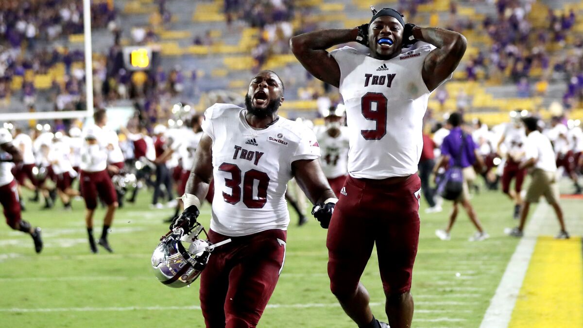 Troy players storm the field to celebrate their upset of Louisiana State on Saturday night in Baton Rouge, La.