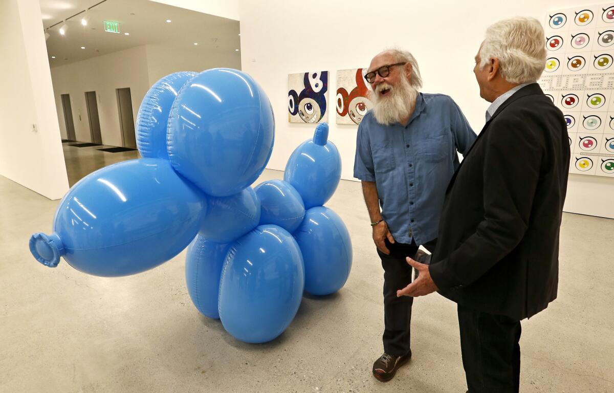 Maurice Marciano, right, chats with artist Paul McCarthy by one of McCarthy's pieces before the foundation's grand opening in 2017.