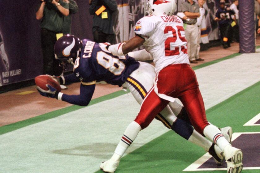 Minnesota Vikings wide receiver Cris Carter holds tight to a 12-yard touchdown pass against Arizona cornerback Corey Chavous in 2000.