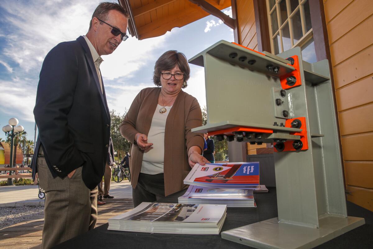 A man and woman look over earthquake retrofitting materials 
