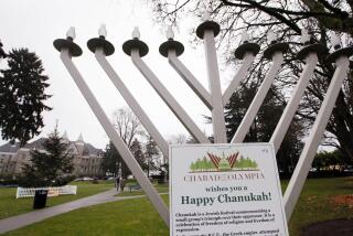 A menorah stands in a public park and in view of a nearby "holiday tree" in a public park not far from the Capitol campus Wednesday, Dec. 21, 2011, in Olympia, Wash. The holiday displays that have previously competed for attention on the state’s Capitol campus are now co-existing peacefully. A Nativity scene was set up a couple of hundred feet away from a display that declares “there are no gods.” State officials have been grappling in recent years with how to balance the First Amendment issues of religion and free speech. In 2008, displays within the Capitol escalated into a controversy and the state eventually declared a moratorium on the exhibits. (AP Photo/Elaine Thompson)