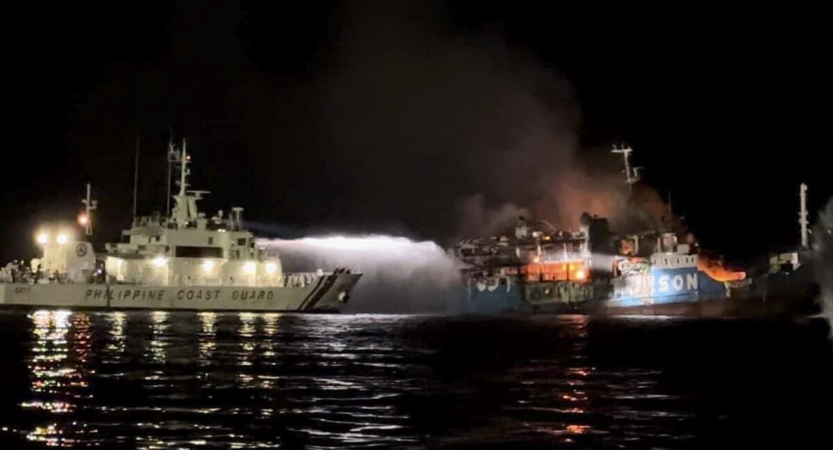 Philippine Coast Guard ship spraying water to extinguish ferry fire