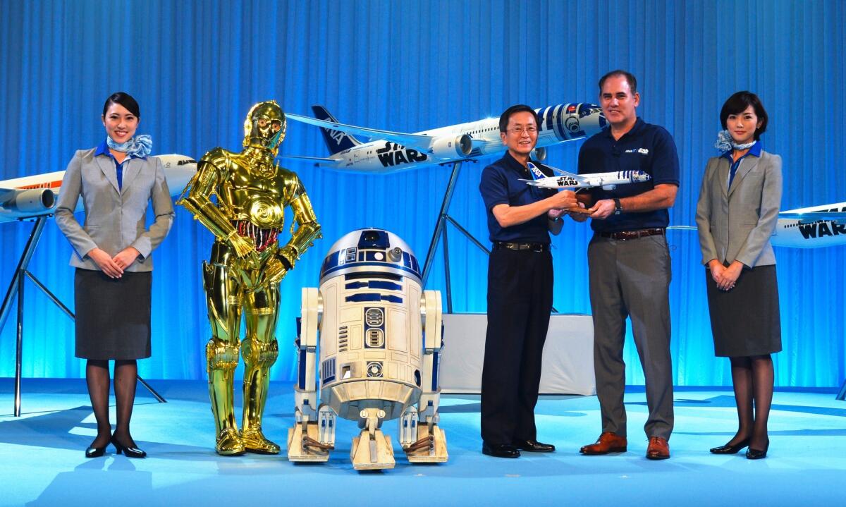 Characters from Star Wars and mock-up planes with All Nippon Airways president Shinobe Osamu (third from right) and Walt Disney Japan president Paul Candland (second from right).