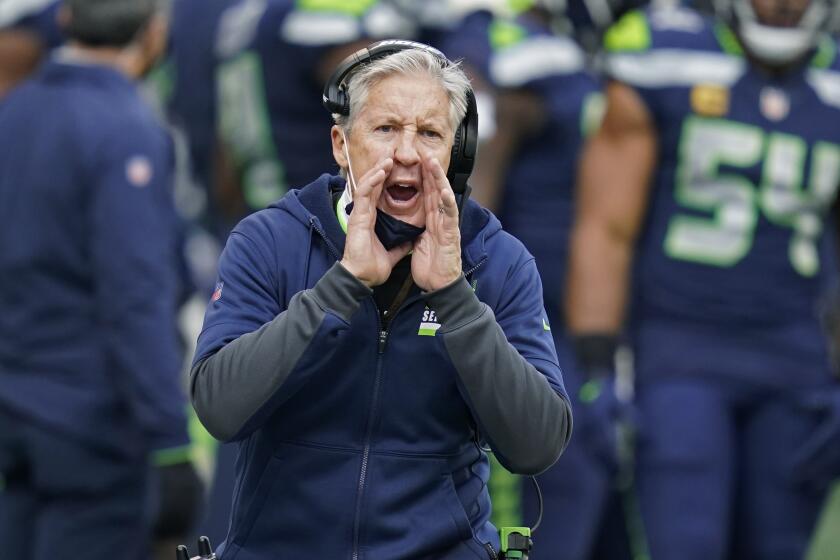 Seattle Seahawks head coach Pete Carroll calls to his team during the first half of an NFL.
