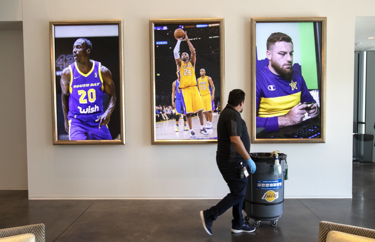 A rotating video board at the Lakers' El Segundo facility features, from left, Andre Ingram of the South Bay Lakers, Kobe Bryant and Shane Farrar of the Lakers esports team.