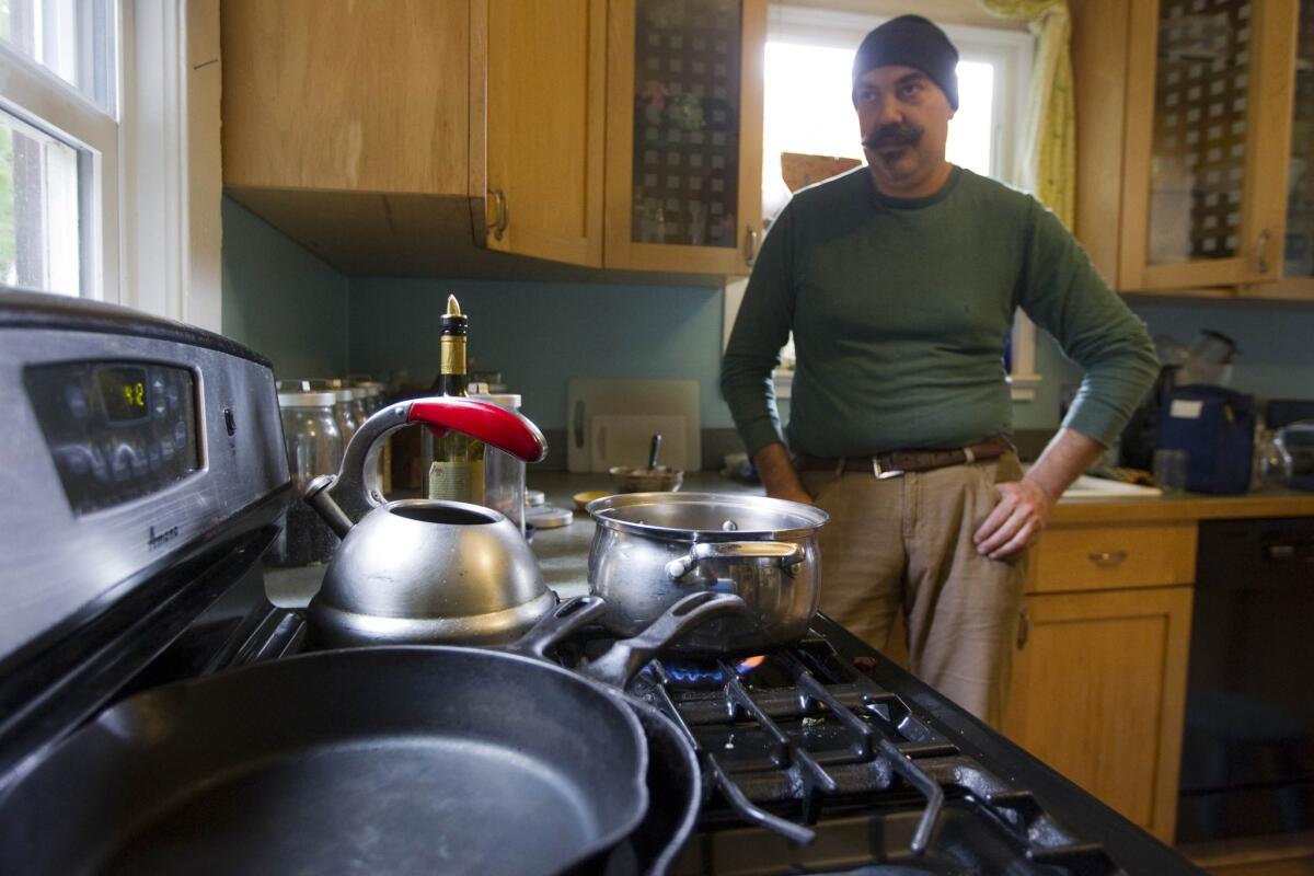 Musician Eric Stern waits for water to boil Friday in Portland, Ore.