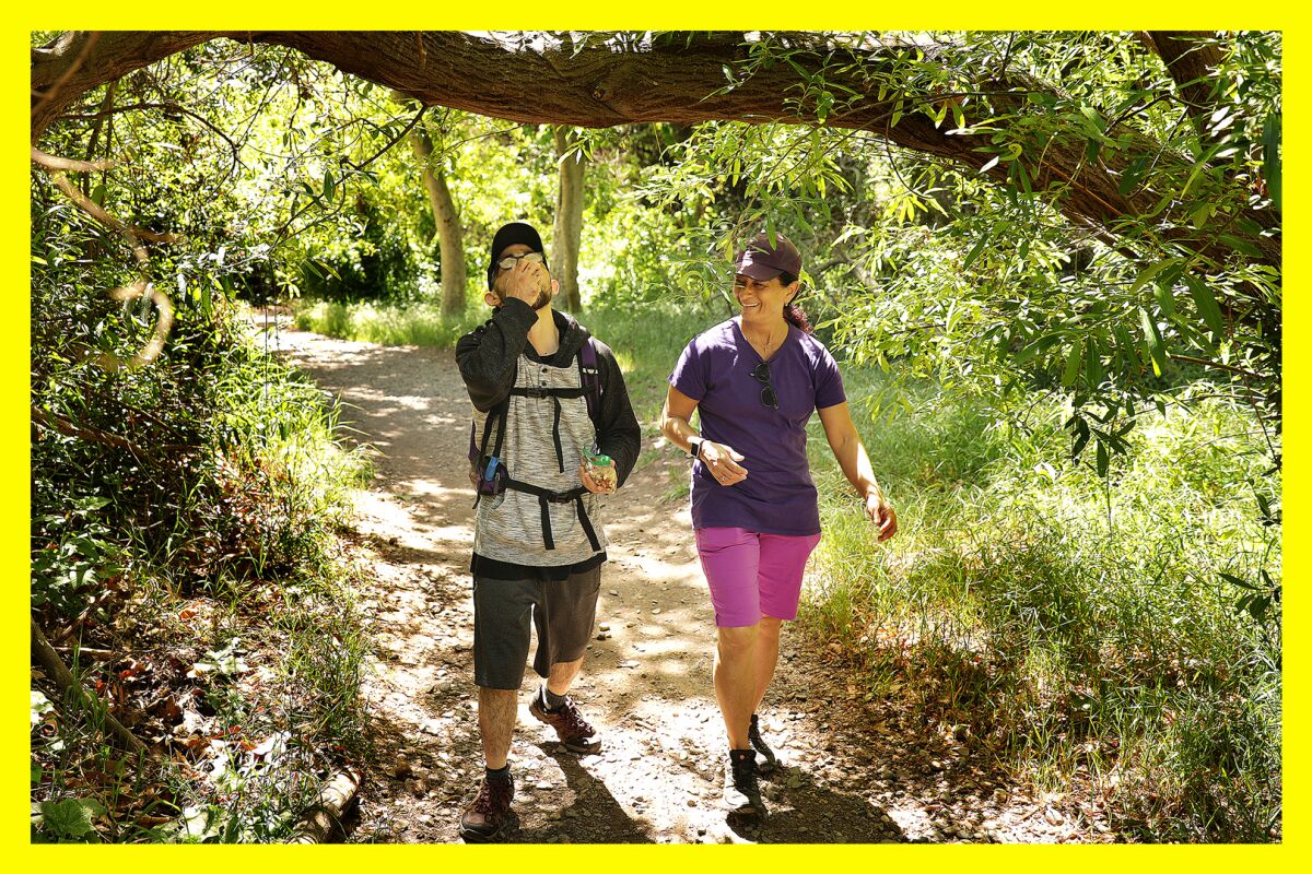 A couple hikes side by side on a trail