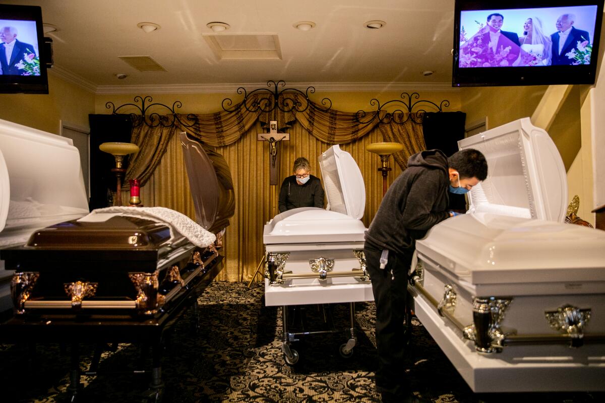  Sammy Deras (right), a funeral attendant, and Kristy Oliver, an embalmer and funeral director, make final preparations.