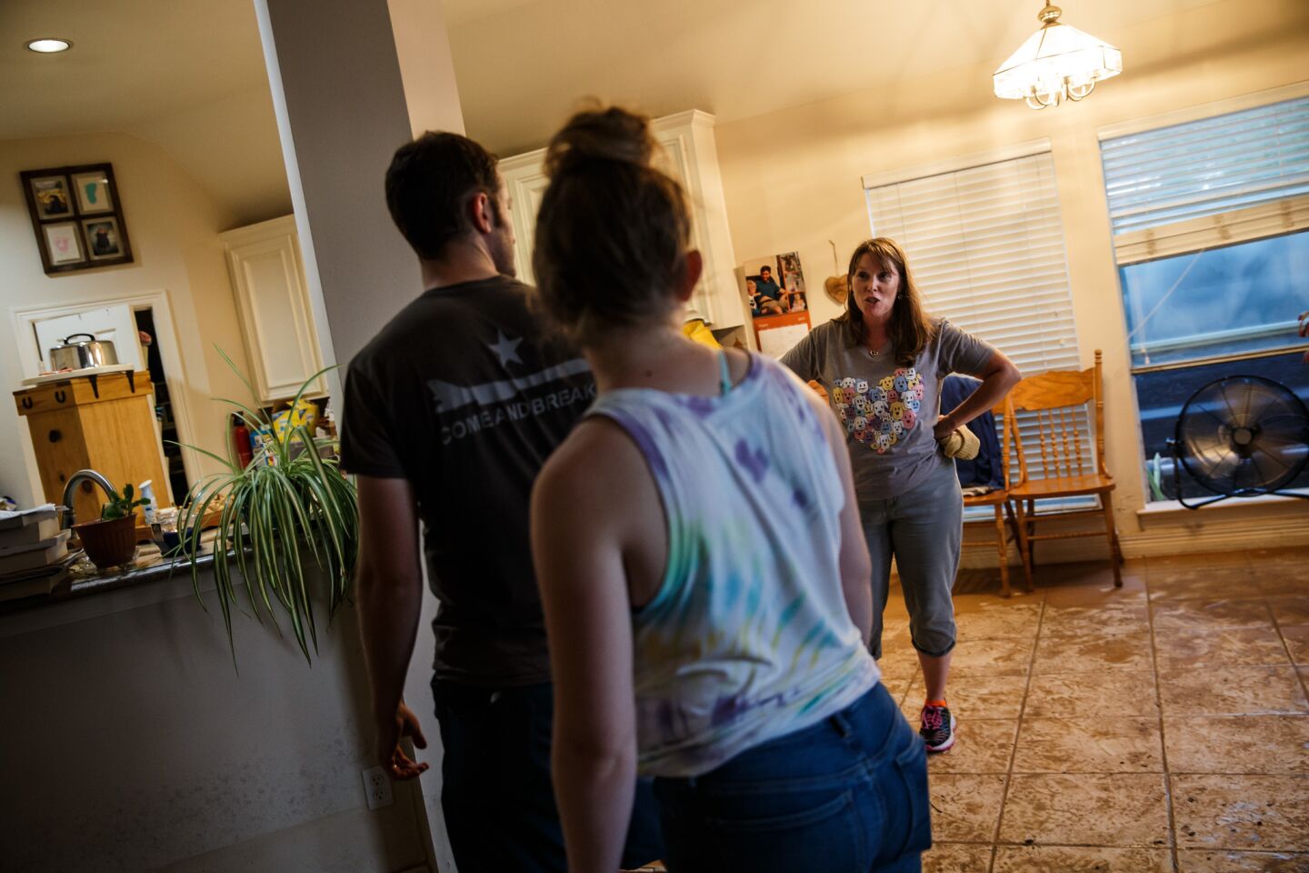 Melissa Teague, right, instructs her children Andrew and Emily as they clear out their flooded home in Katy, Texas, on Monday.