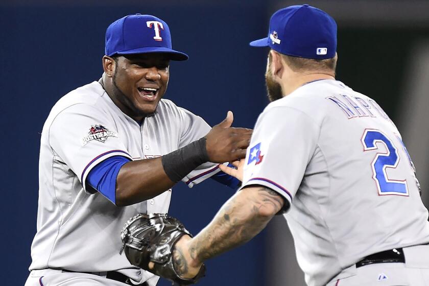 Texas Rangers' Hanser Alberto, left, celebrates with teammate Mike Napoli following their win over the Toronto Blue Jays after the 14th inning on Friday.