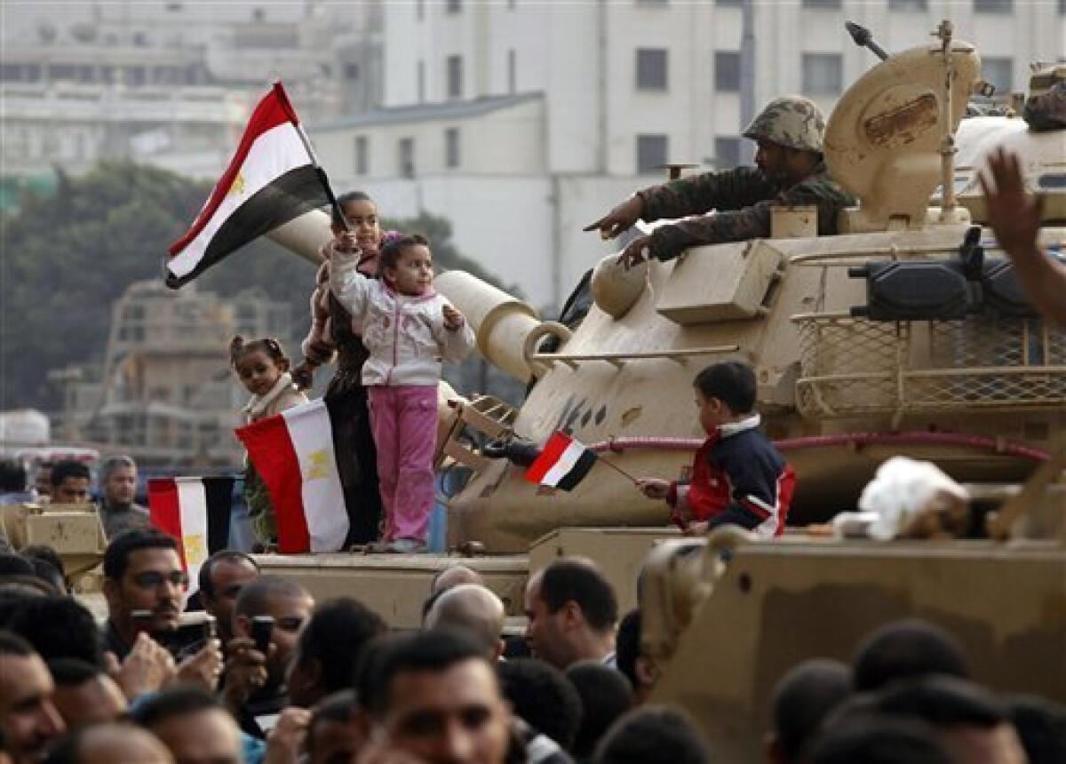 Young girls wave Egyptian flags atop an armored vehicle just outside Tahrir or Liberation Square in Cairo, Egypt, Tuesday, Feb. 1, 2011. More than a quarter-million people flooded into the heart of Cairo Tuesday, filling the city's main square in by far the largest demonstration in a week of unceasing demands for President Hosni Mubarak to leave after nearly 30 years in power. (AP Photo/Victoria Hazou)