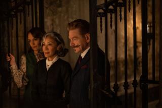 Tina Fey, Michelle Yeoh and Kenneth Branagh stand at a gate in Venice in the movie "A Haunting in Venice."