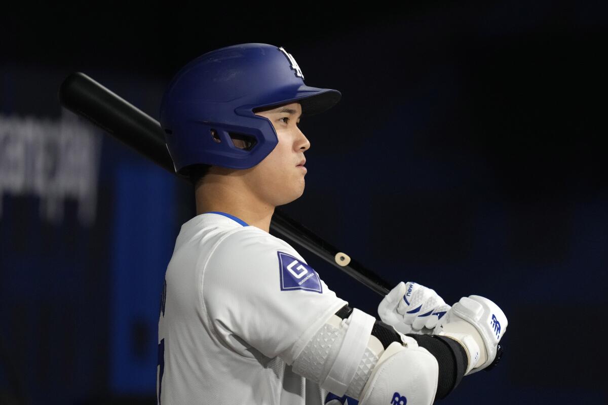Dodgers designated hitter Shohei Ohtani stands in the dugout as he gets set to bat during Thursday's game against the Padres.