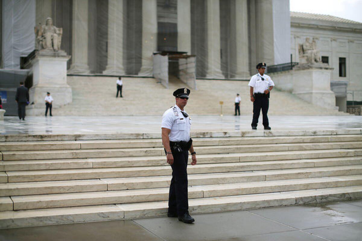 Police stand guard in front of the U.S. Supreme Court building.
