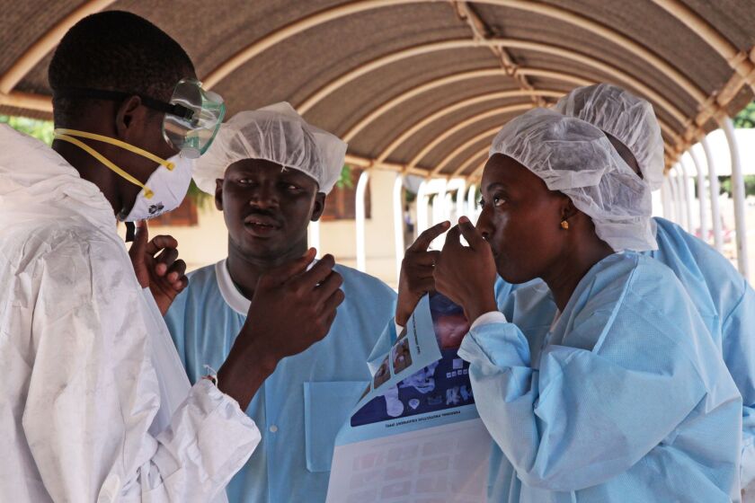 Healthcare workers in Kayes, Mali, get briefed Oct. 25 on the use of protective gear.