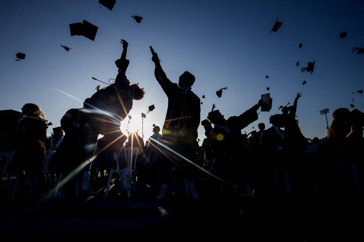 Newport Harbor High School seniors toss their caps.