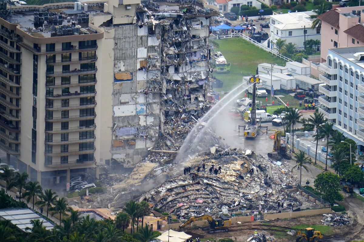 FILE - In this June 25, 2021, file photo, rescue personnel work at the remains of the Champlain Towers South condo building in Surfside, Fla. A judge says a mediator will be named to sort through claims arising from the collapse of a Florida condominium that killed 98 people. Miami-Dade Circuit Judge Michael Hanzman said at a hearing Wednesday, Oct. 6, 2021 that he is hoping to avoid a bitter and lengthy battle over money by victims. (AP Photo/Gerald Herbert, File)
