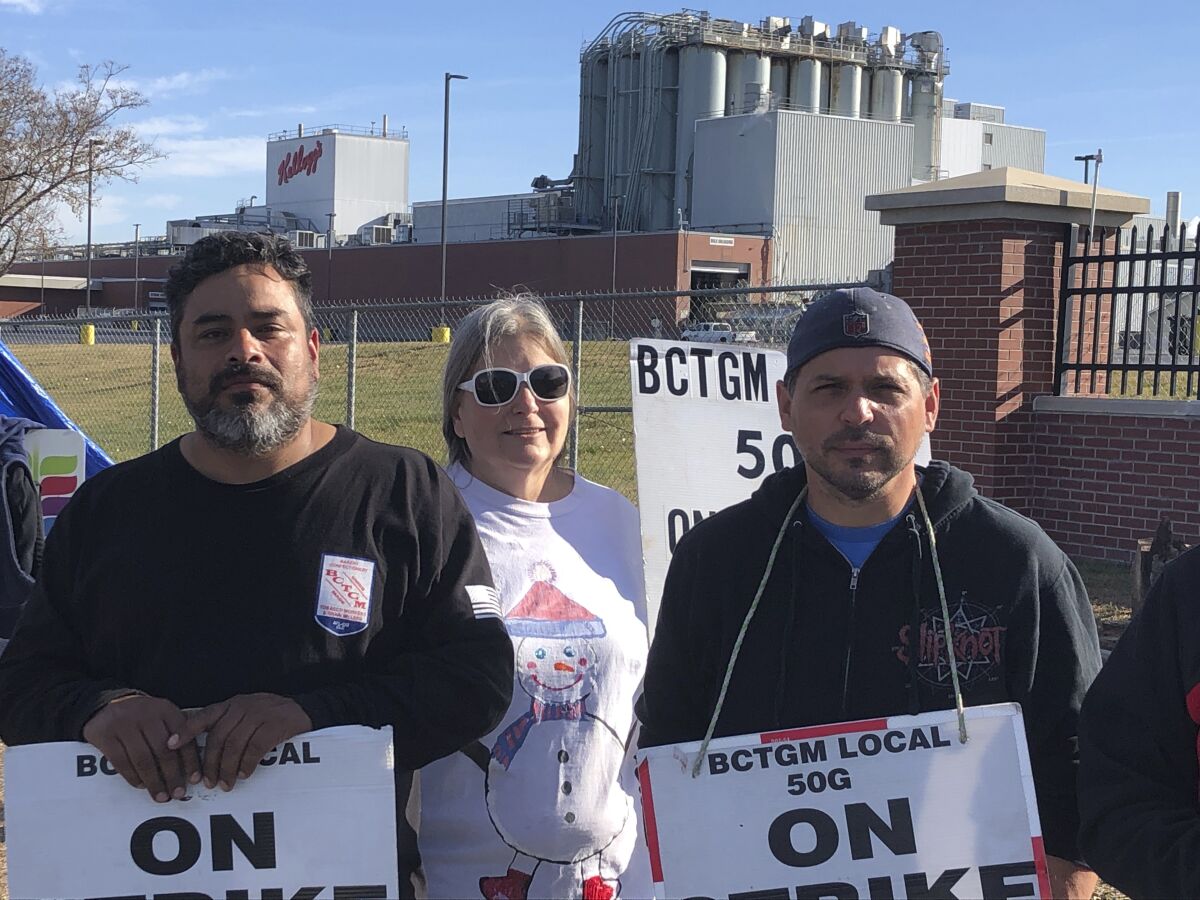 Striking Kellogg's workers Michael Rodarte, Sue Griffin and Michael Elliott stand outside the Omaha, Neb., cereal plant Thursday, Dec. 2, 2021. The company and the union announced Thursday that they have reached a tentative contract agreement. (AP Photo/ Josh Funk)