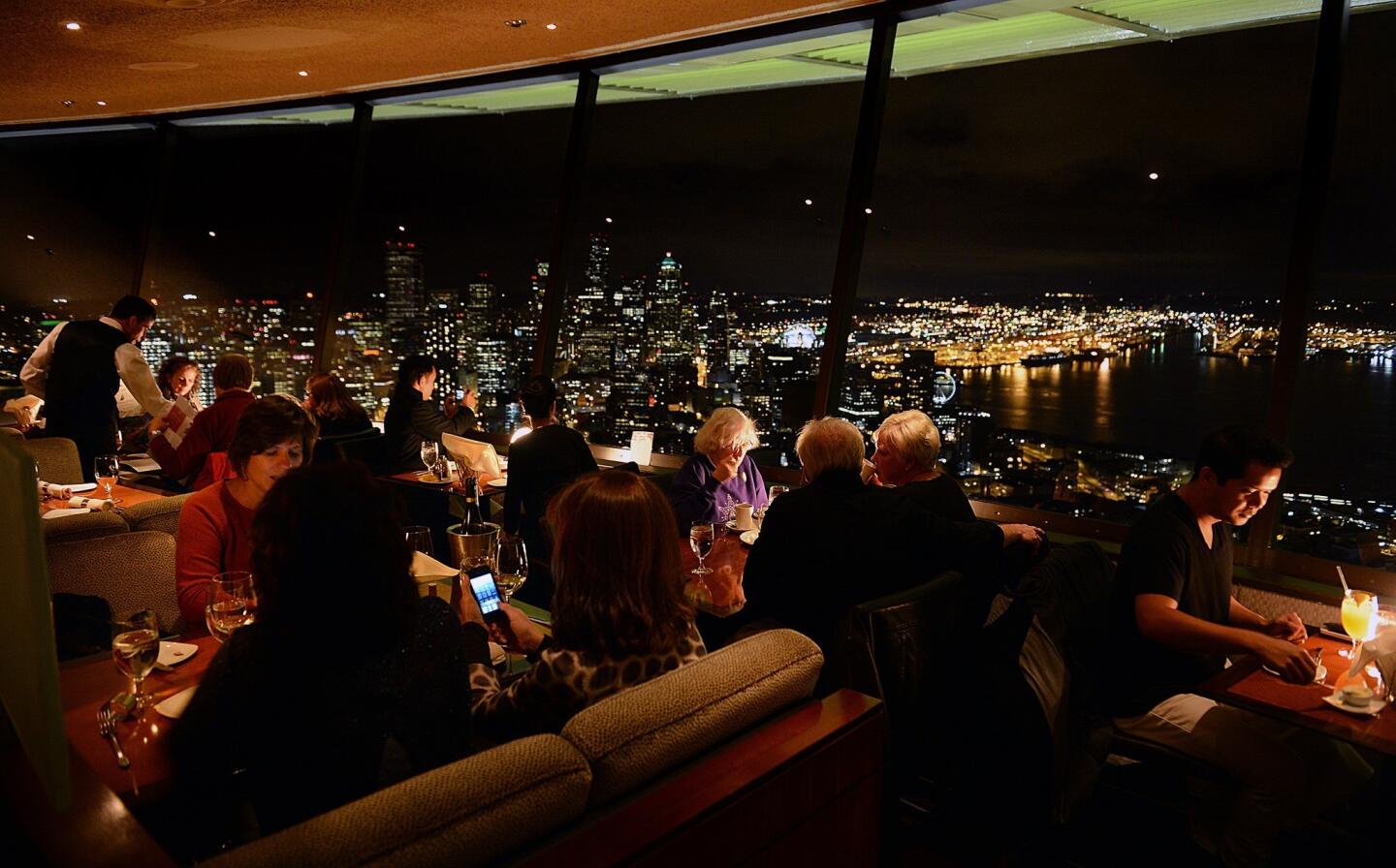 Diners enjoy food and cocktails at the SkyCity restaurant at the top of the Space Needle.