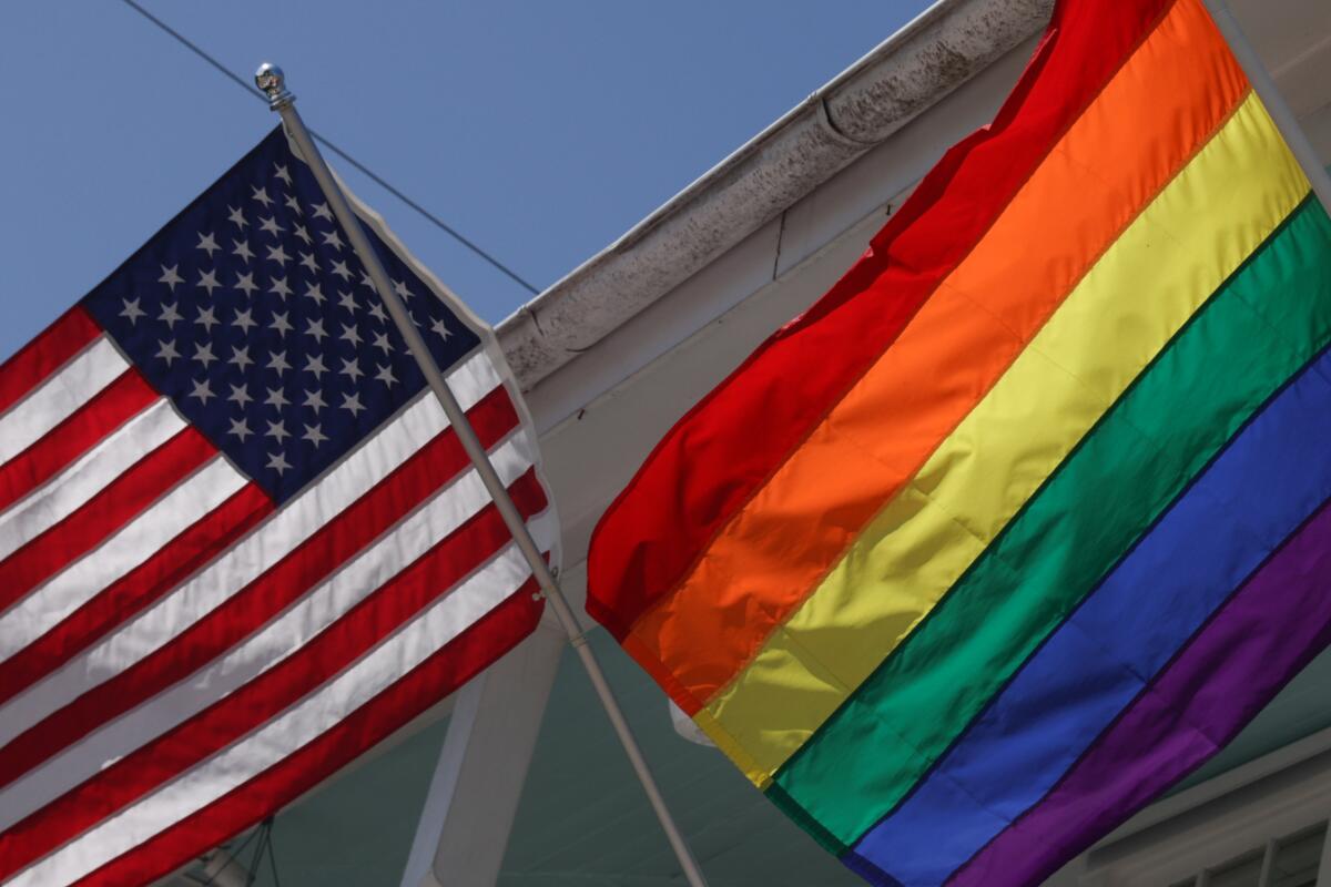 American and LGBT flags are displayed side by side.