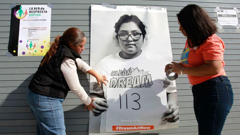 Natchel Bello, right, a rally organizer and DACA recipient, and Maribel Solache, the mother of a dreamer, put up a poster showing a DACA recipient holding a sign with the number of days left before her permit expires.