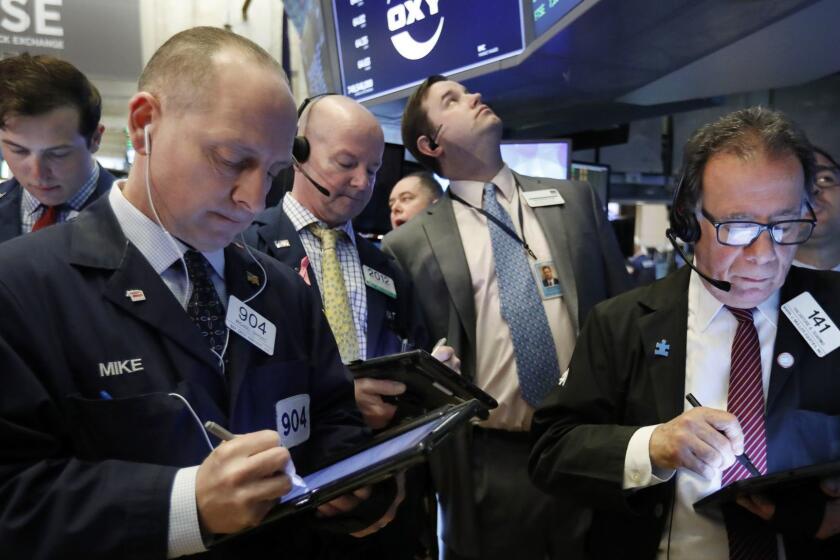 Traders gather at the post that handles Oaktree Capital Group on the floor of the New York Stock Exchange, Wednesday, March 13, 2019. U.S. stocks opened broadly higher on Wall Street Wednesday, powered by technology and health care companies, as the market pushes for its third straight day of gains. (AP Photo/Richard Drew)