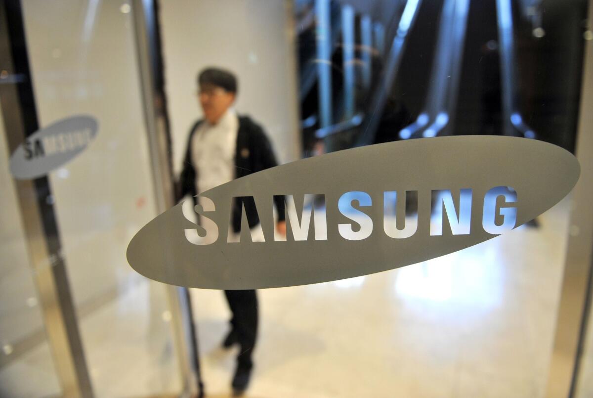 A man walks past a logo of Samsung Electronics at the company's headquarters in Seoul.