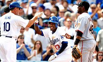 Dodgers third base coach Larry Bowa congratulates second baseman Orlando Hudson, who tripled in the sixth inning.