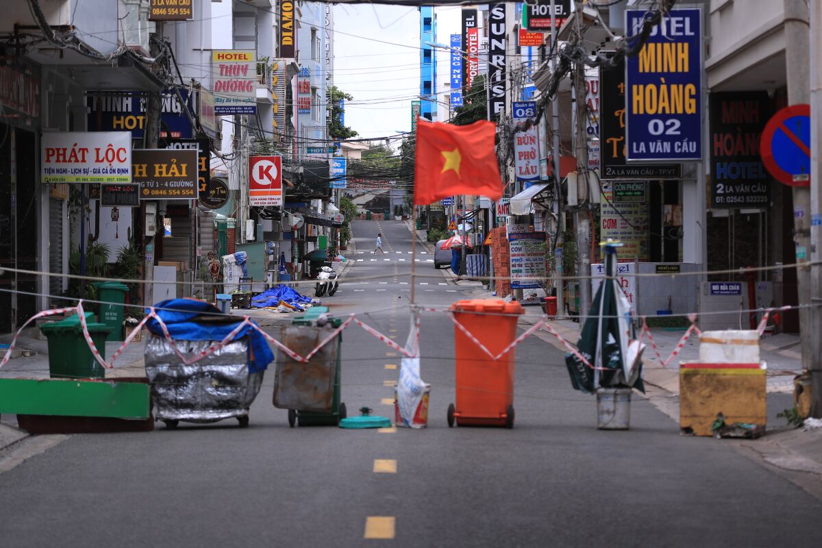 An alley is blocked with trash can and a Vietnamese flags in Vung Tau, Vietnam.