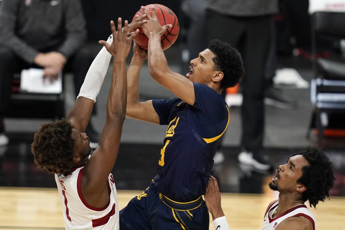 California's Jarred Hyder shoots over Stanford's Daejon Davis and Bryce Wills.