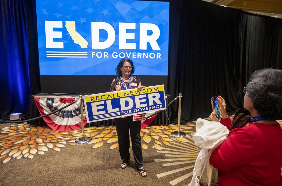 Gloria Kalatzis has her picture taken at the victory party for candidate Larry Elder at the Hilton Orange County.