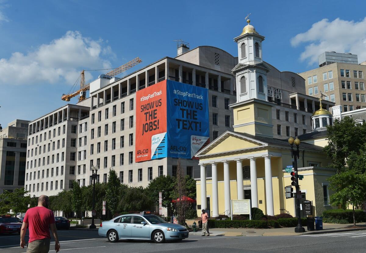 Banners opposing a bill that would give President Obama fast-track trade negotiating authority hang from the headquarters of the AFL-CIO in Washington.