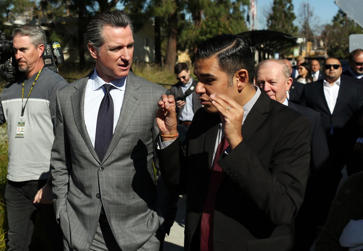 Gov. Gavin Newsom, center left, and Long Beach Mayor Robert Garcia, right, tour Century Villages at Cabrillo, an affordable housing development, on Tuesday.