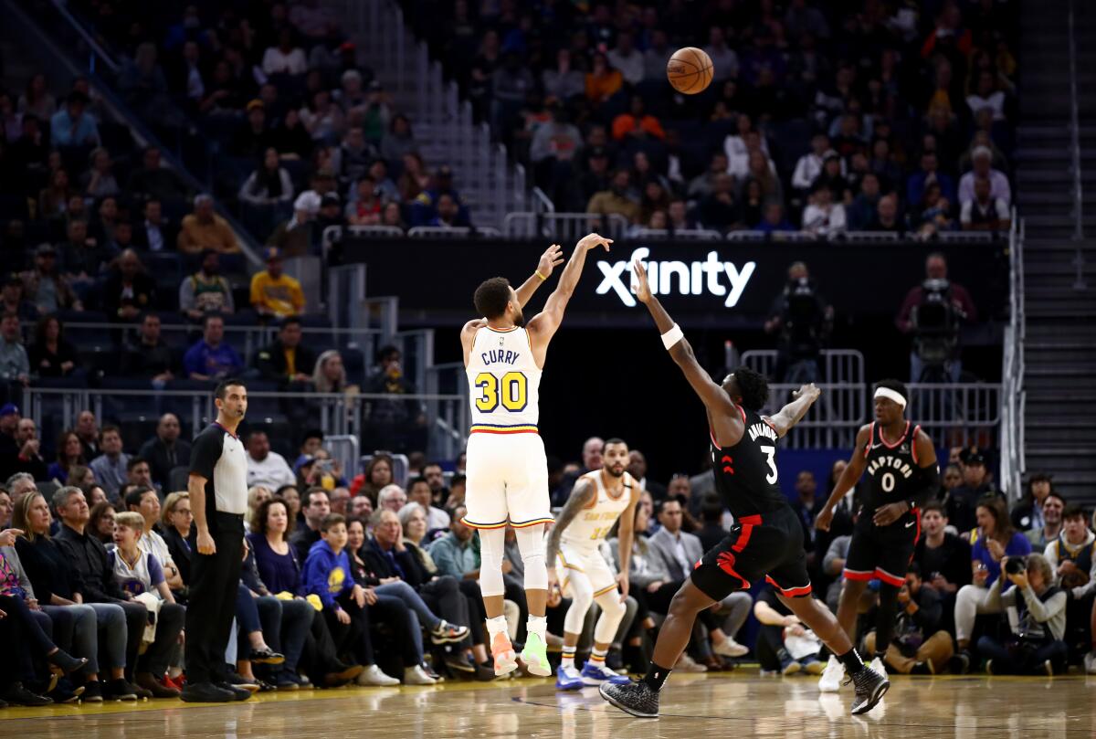 Stephen Curry hits a three-pointer during his first game back for the Warriors since breaking his wrist four month ago.